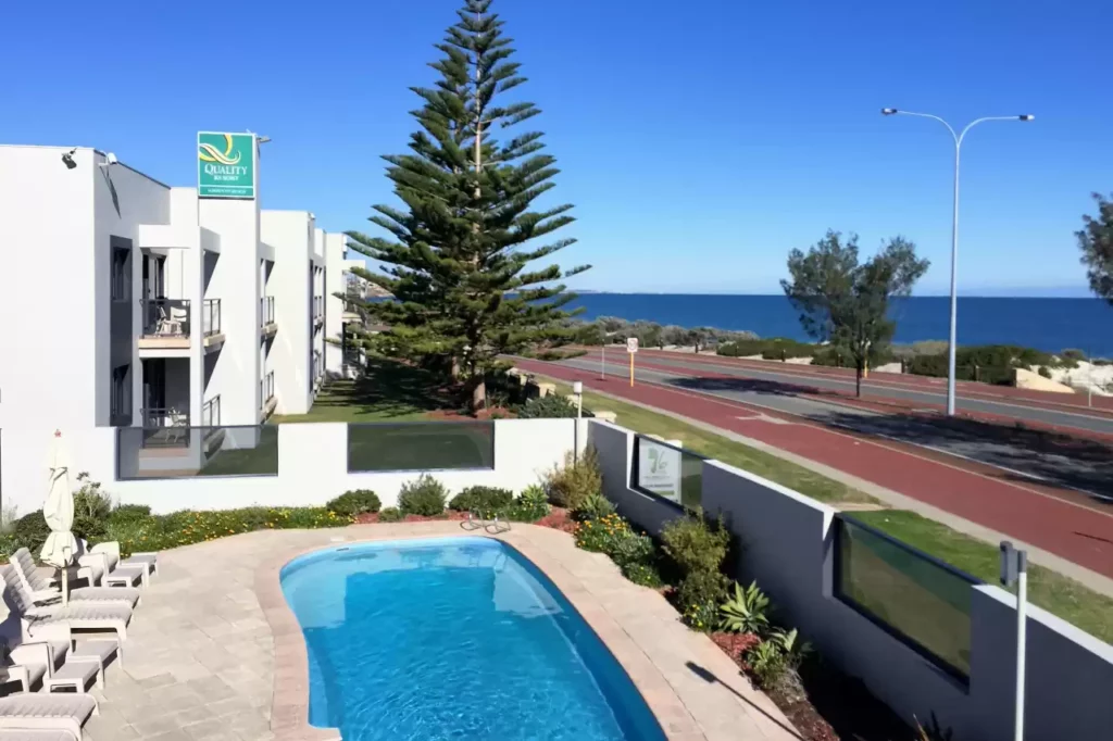 Park of the pool deck with the ocean in the background at Quality Resort Sorrento Beach